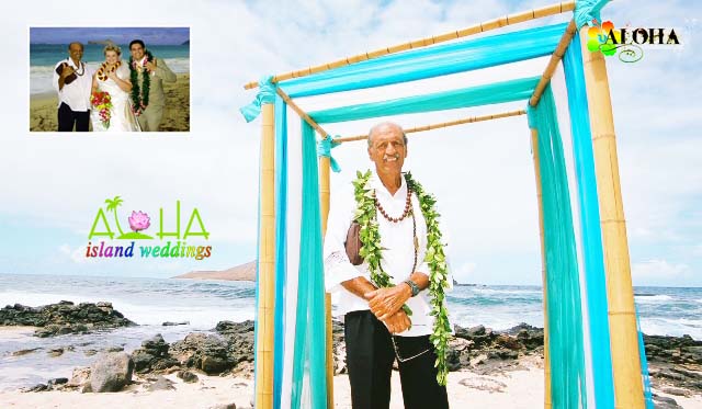 Minister Fuller wearing a maile lei under a turquoise draped arch on the beach